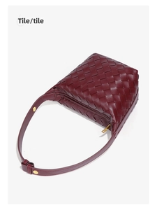 Close-up of deep red woven leather texture with elegant golden metal snap buckle