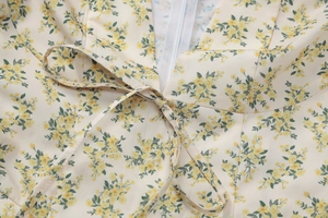 Détail du décolleté en V et du lien frontal sur robe en mousseline fleurie beige