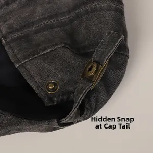 Detail of adjustable snap button closure on vintage dark grey punk style flat cap