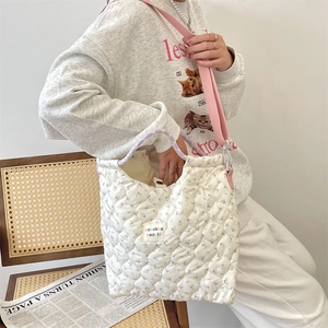 Sac fourre-tout matelassé à fleurs avec bandoulière rose porté par un mannequin