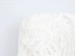 Détail macro de tissu en dentelle florale blanche avec broderie ajourée complexe