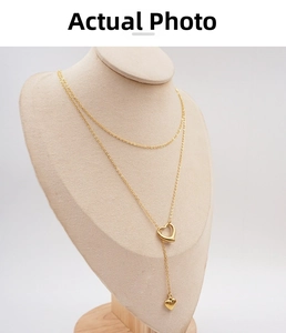 Detailed view of gold Y-shaped layered necklace with open heart pendant on mannequin