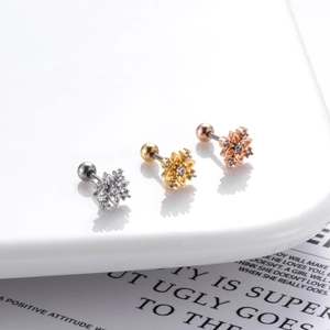 Macro detail of flower stud earrings in silver, gold, and rose gold with zircon