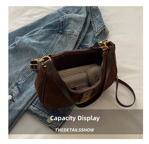 Spacious interior of a dark brown suede shoulder bag with daily essentials inside