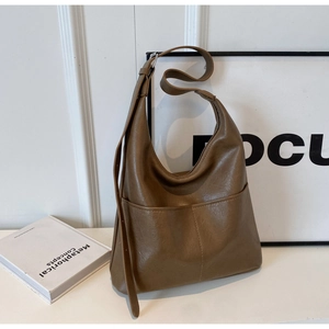 Detail of a brown PU leather crescent shoulder bag with two functional front pockets