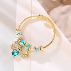 Bracelet ajustable torsadé doré avec charms bleus, pendentif ours et détails de cœur