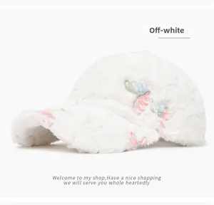 Detailed close-up of off-white plush baseball cap featuring delicate floral embroidery