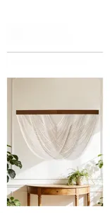 Detail of bohemian hand-woven cotton tapestry with dark wood beam and elegant wall decor