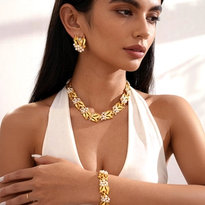 Close-up of pearl leaf jewelry set on model featuring gold finish and crystal details