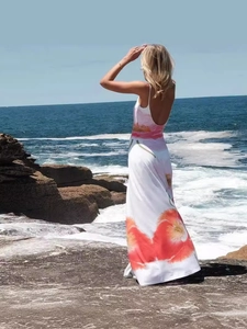 Floral backless maxi dress with spaghetti straps and orange flower print by the sea