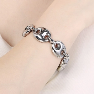 Macro shot of silver-toned coffee bean link bracelet showing heavy metal texture