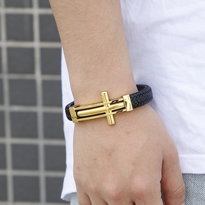 Primer plano de pulsera para hombre en cuero trenzado negro con cierre de cruz dorada
