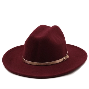 Détail de chapeau fedora en laine bordeaux avec sangle en cuir et boucle en or rose