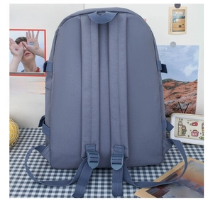 Detail view of adjustable padded straps and reinforced buckles on a grey-blue backpack