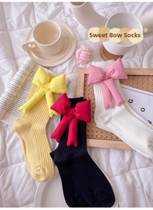 Detail view of cotton ribbed socks featuring large 3D detachable bows in vibrant colors
