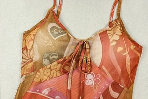 Dettaglio vestito in mesh con stampa floreale e cuori, lacci e spalline sottili