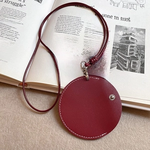 Detail view of dark red leather glasses holder necklace with white stitching and silver snap