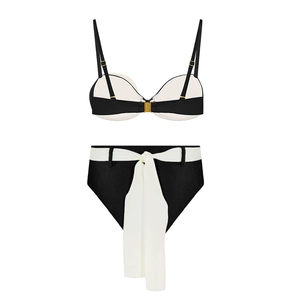 Detail of high waisted black bikini bottoms with a contrasting white bow belt detail