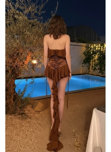 Detail of caramel halter dress featuring back ruching and layered ruffle trail design