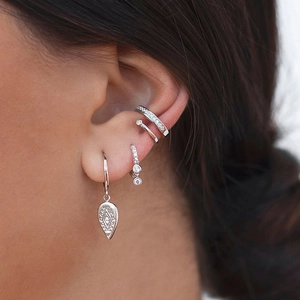 Détail de manchettes d'oreilles argentées à double couche et boucles d'oreilles zircon