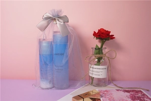 Detail of cosmetics set in a lavender organza bag with pearl bow and satin ribbon