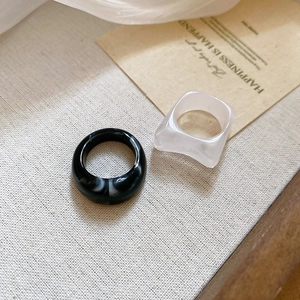 Detail of two minimalist acrylic resin rings with ink and frosted marble texture