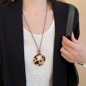 Detail of tortoiseshell resin ring pendant on brown wax cord necklace for women