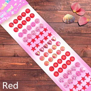 Macro detail of mixed red jewel stickers in flower, star and heart shapes for DIY craft