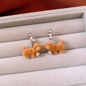 Detail shot of brown flocked puppy earrings with heart-shaped zircon stones and silver hooks