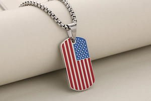 Detailed close-up of oval stainless steel military tag pendant with US flag pattern