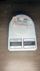 Detailed view of 10x8.5cm puzzle-shaped acrylic gift for Mom on weighing scale