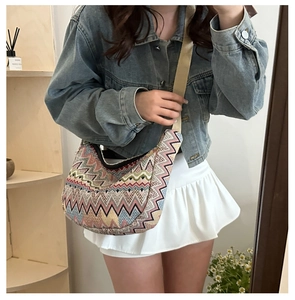 Vue détaillée d'un sac bandoulière en tricot en forme de croissant aux motifs colorés