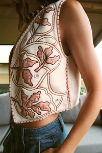 Detail of vintage beige floral embroidery vest with mirror effects and professional stitching
