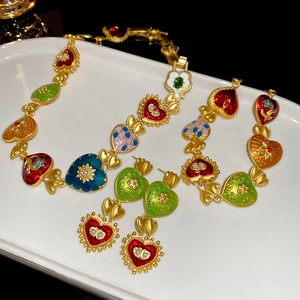 Vintage palace style heart jewelry set with colorful enamel and pearls on white tray