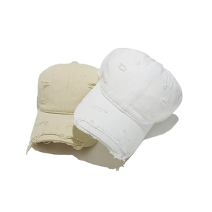 Detailed view of distressed vintage cotton baseball caps with torn edges and worn holes