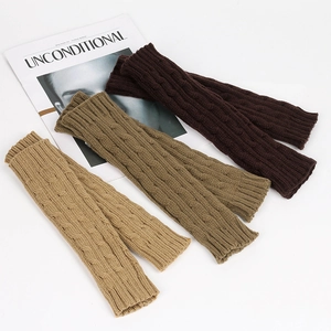 Detail of three pairs of cable knit leg warmers in dark brown, medium brown, and beige