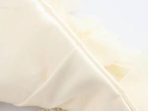 Macro shot of beige satin fabric texture and seam detail for beach style crop top