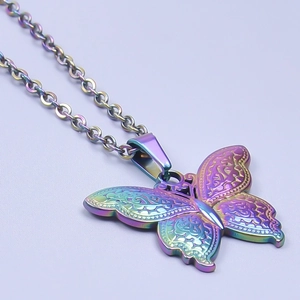Vue macro d'un pendentif papillon en acier inoxydable arc-en-ciel avec gravure fine
