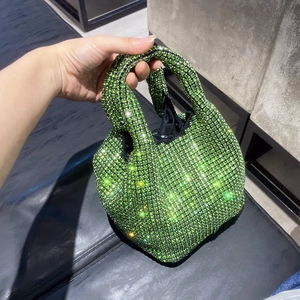 Detailed view of vibrant lime green rhinestone encrusted mini bucket bag with silver handle