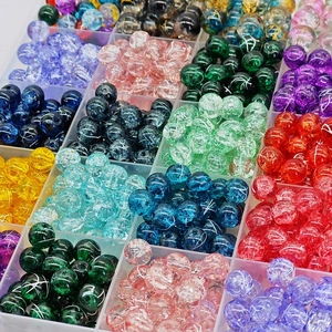 Detailed view of colorful crackle glass beads organized in a transparent storage case