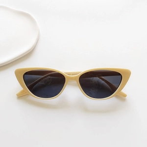 Close-up of retro cat-eye sunglasses with cream resin frames and dark gray lenses
