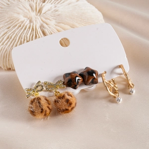 Six-piece earring set with diamond bows, fur balls, and star studs on velvet fabric