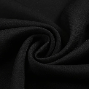 Close-up of black evening dress fabric showing elegant pleated texture and premium quality