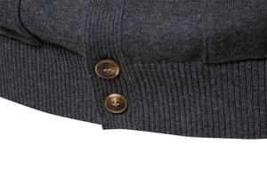 Detailed macro view of dark grey knit cardigan fabric with premium brown wood texture buttons
