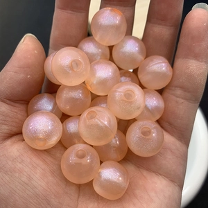 Close-up of peach luminous glitter beads with through holes for DIY jewelry making