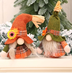 Detail of harvest gnomes with plaid fabric and sunflower accents on snowy background