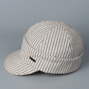 Detail of gray striped newsboy cap featuring a side decorative patch and textured cotton fabric