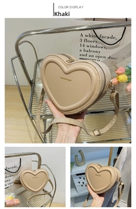 Vue détaillée d'un sac à bandoulière en cuir kaki en forme de cœur avec logo doré