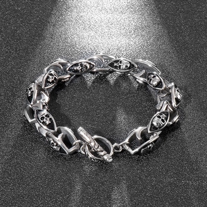 Close-up of double-layered skull link bracelet with T-bar clasp in polished steel