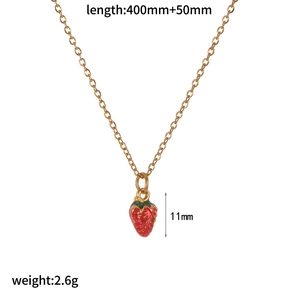 Detail view of a gold chain necklace featuring a red and green strawberry pendant